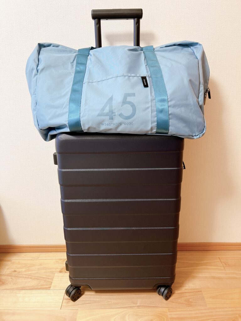 ミレストポケッタブルバッグ45リットルをスーツケースの上に固定したところ（正面）